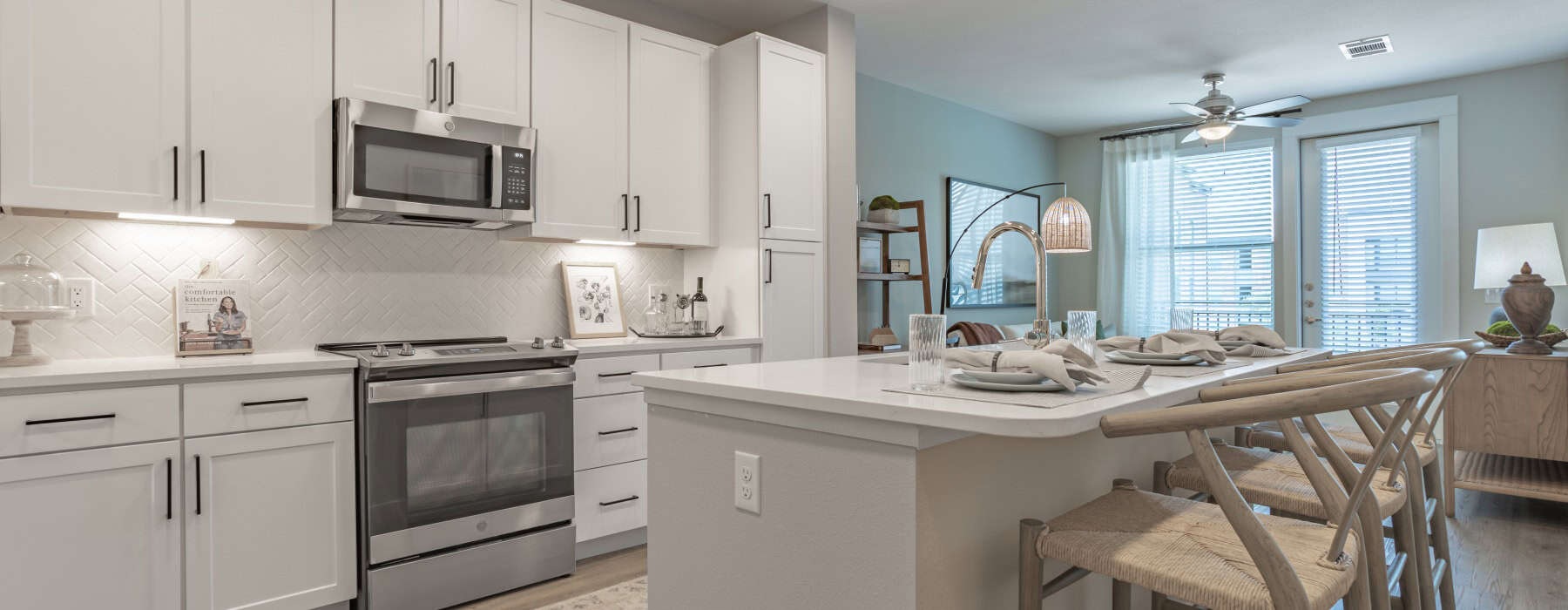 kitchen with white cabinets and island with barstools