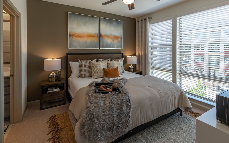 bedroom with ceiling fan, light fixture and oversized windows